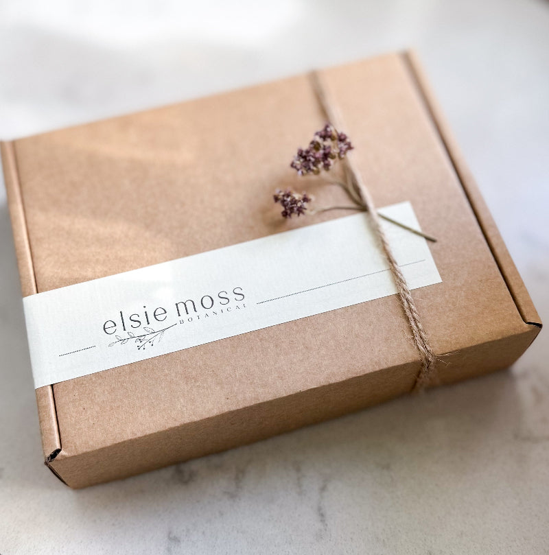 Brown gift box with a white label featuring &