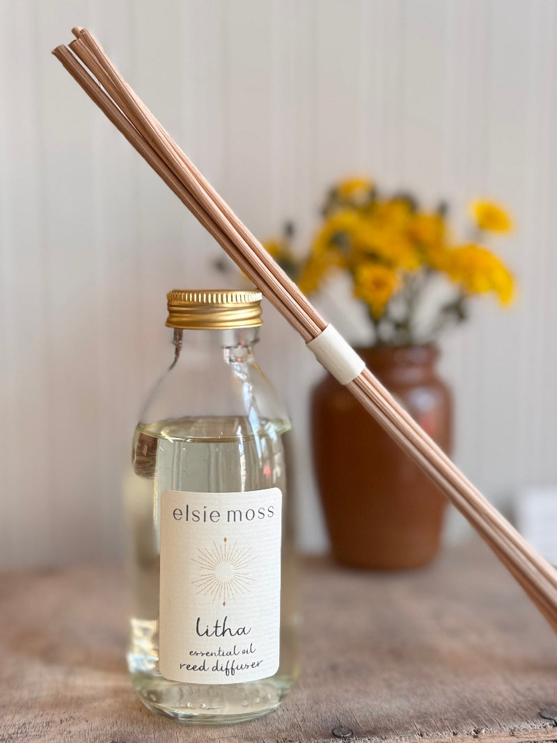 Elsie Moss Litha essential oil reed diffuser with sticks on a wooden surface.