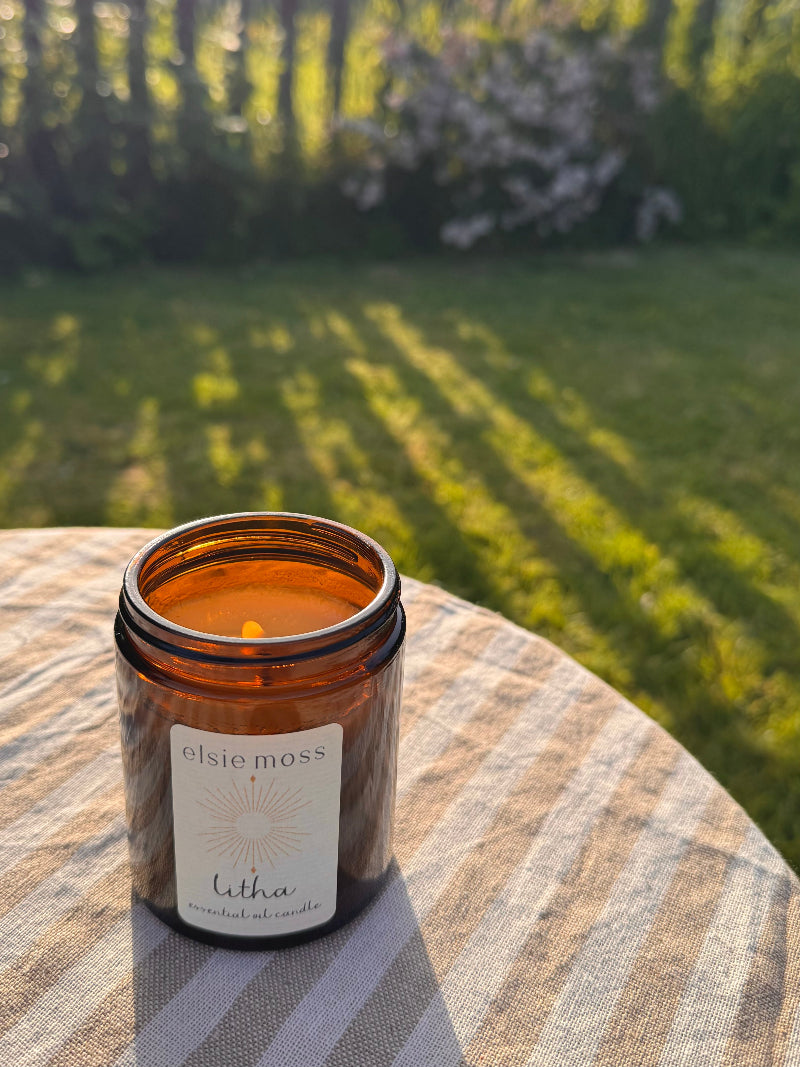 Candle in an amber jar labeled &