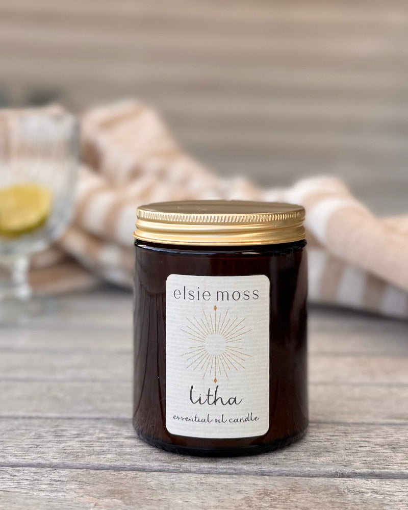 Elsie Moss Litha candle on a wooden surface with a blurred background