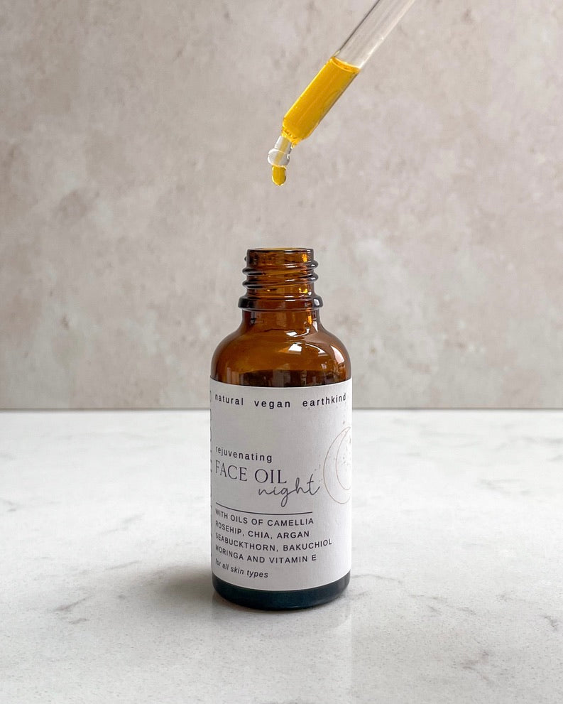 Bottle of face oil with a dropper on a marble surface