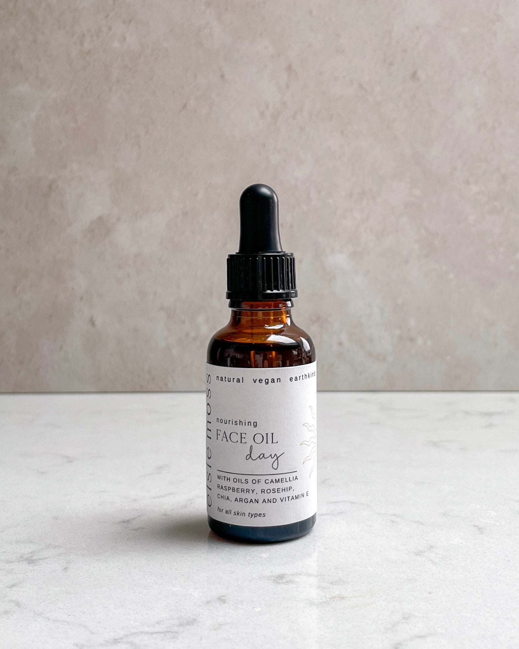 Bottle of face oil with dropper on a marble surface and gray background