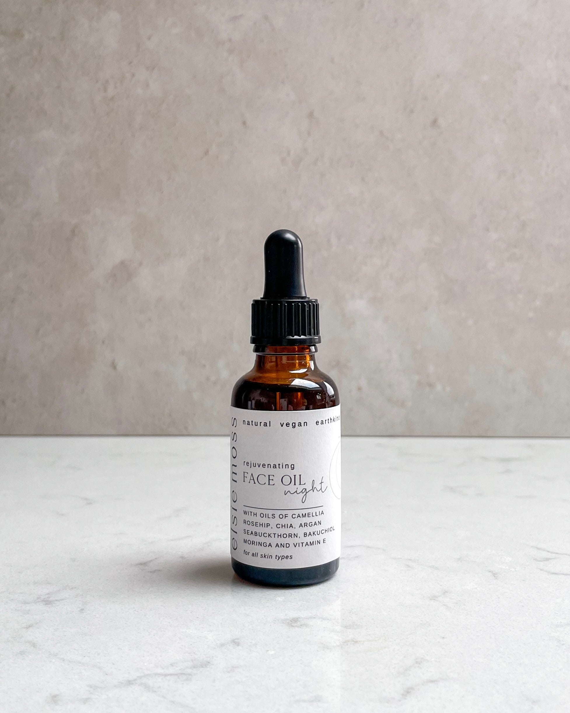 Bottle of face oil with dropper on a light surface and gray background