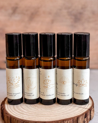 Set of six small amber glass bottles with black caps on a wooden surface.