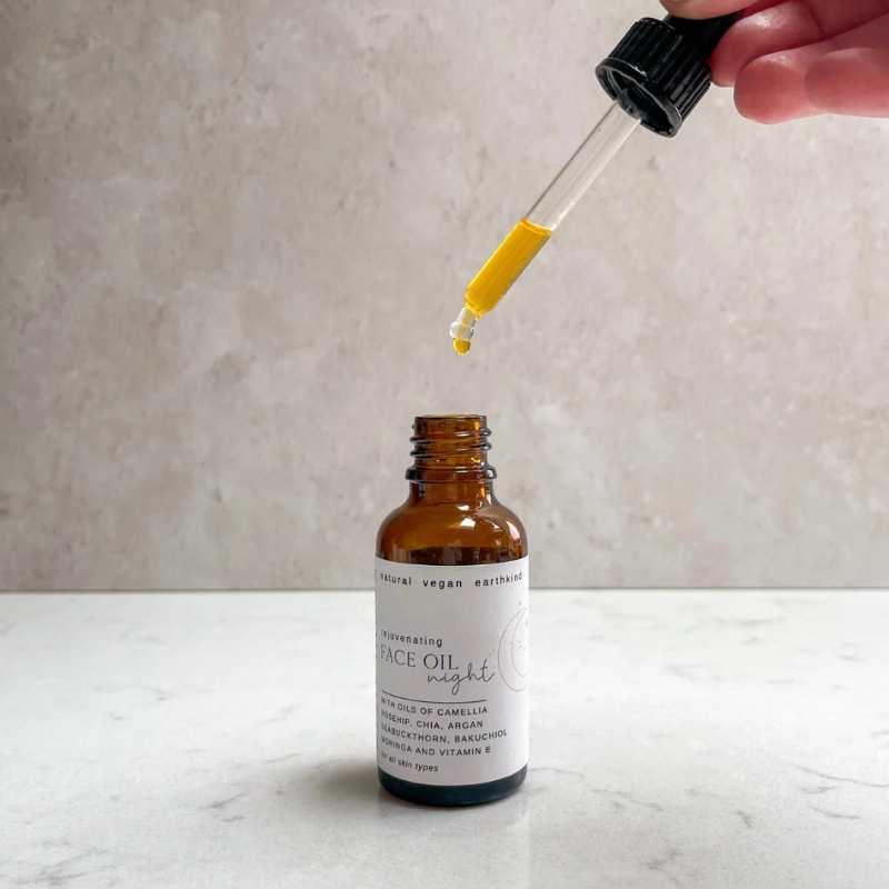 Bottle of face oil with dropper on a neutral background