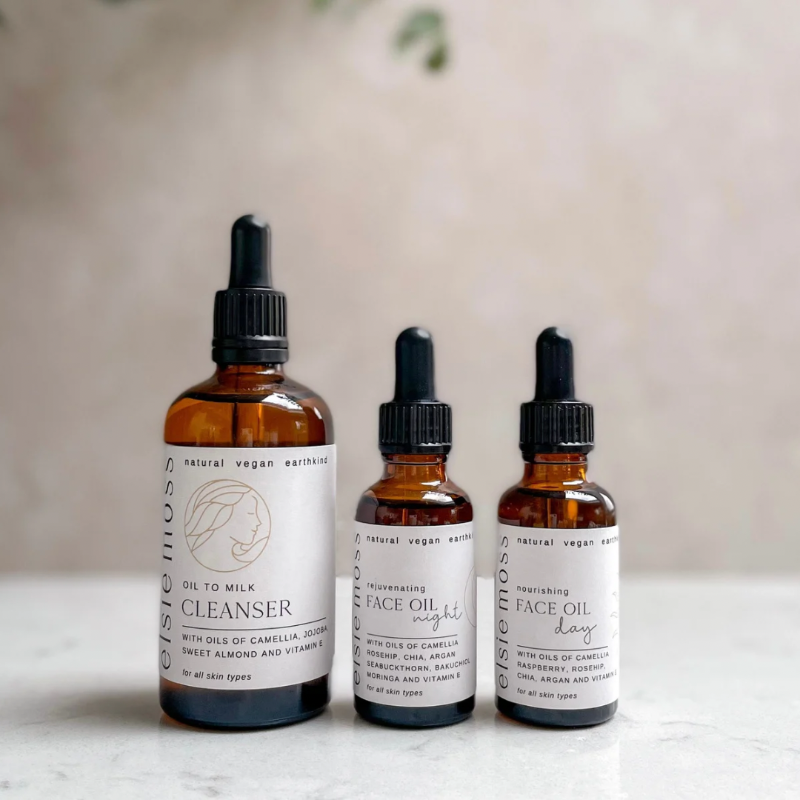 Three bottles of natural skincare products with droppers on a light surface.