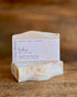 Handcrafted soap bar with a visible label on a wooden surface