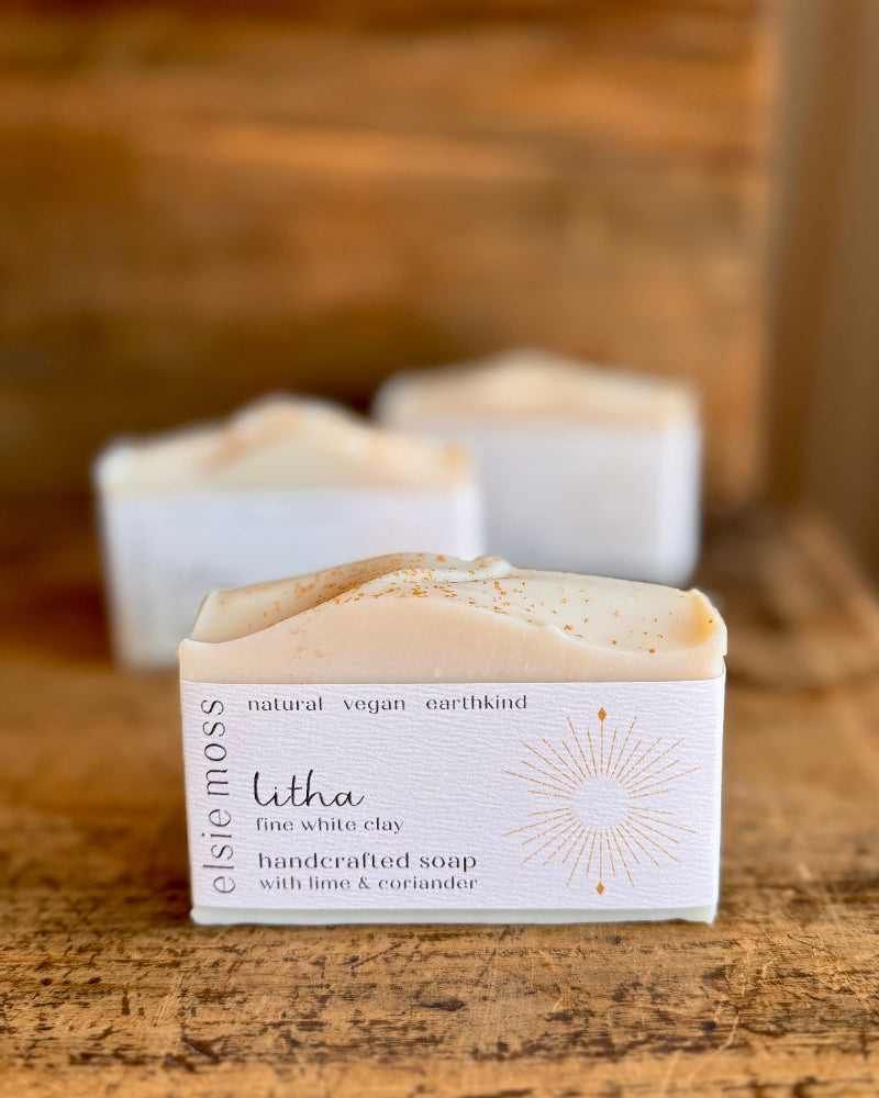 Handcrafted soap bar with packaging on a wooden surface