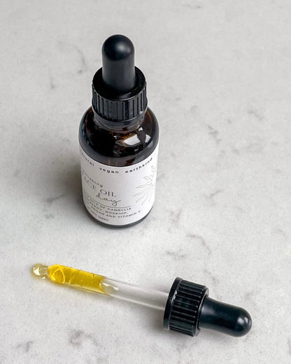 Bottle of face oil with dropper on a marble surface