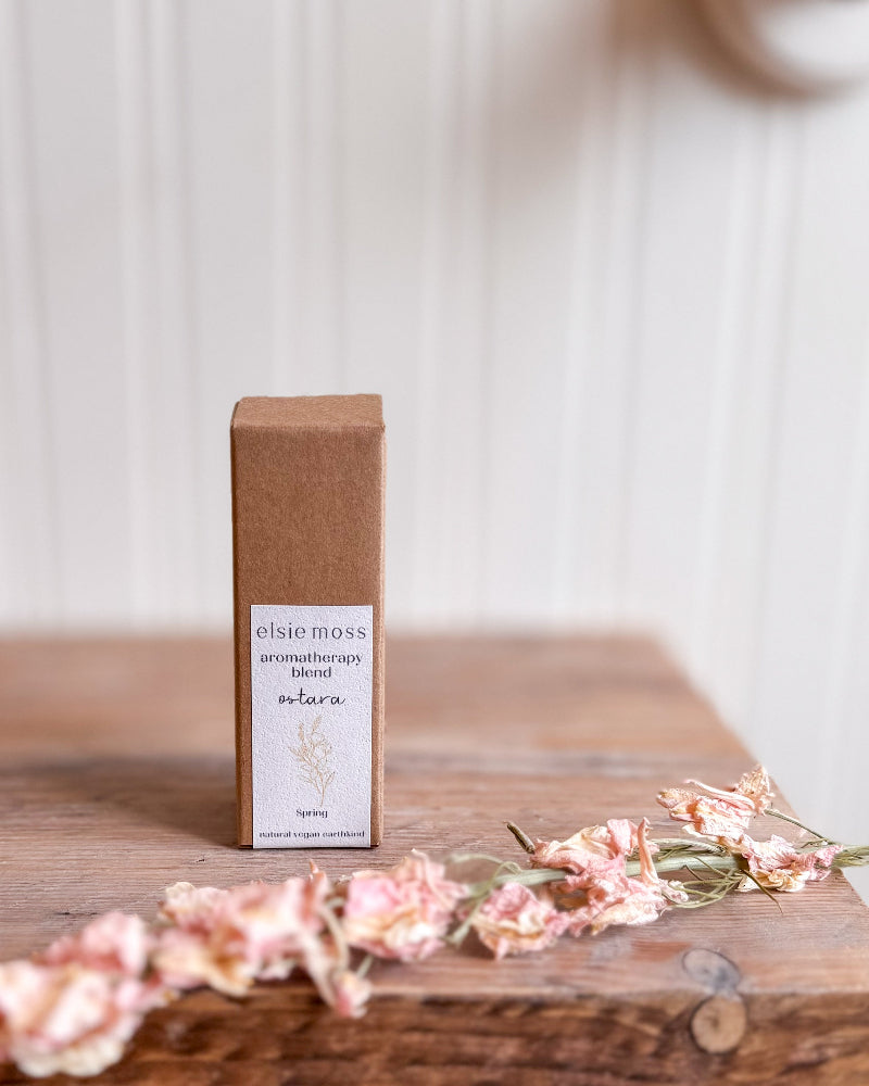 Elsie Moss aromatherapy blend bottle on a wooden surface with flowers