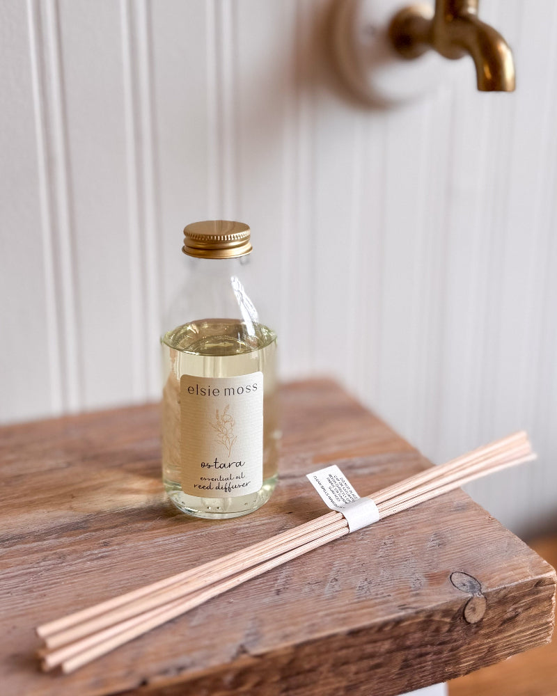 Elsie Moss diffuser bottle with reeds on a wooden surface