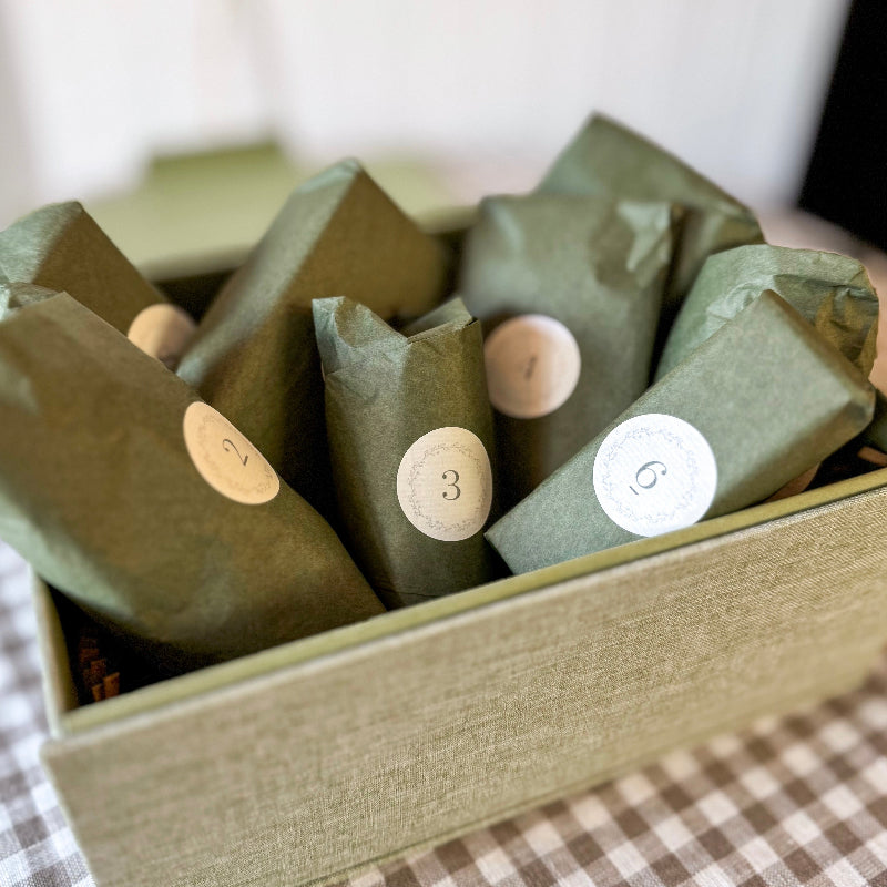 Green wrapped items with numbered labels in a box on a checkered surface