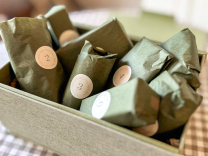 Green wrapped items with numbers in a box on a checkered fabric background