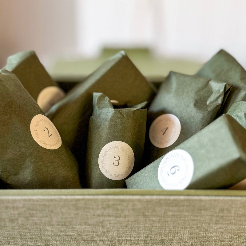 Green paper packages with numbered labels on a textured surface