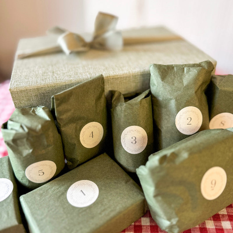 Gifts wrapped in green paper with numbered labels on a checkered tablecloth.