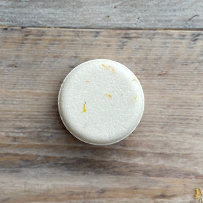 White shampoo bar on a wooden surface