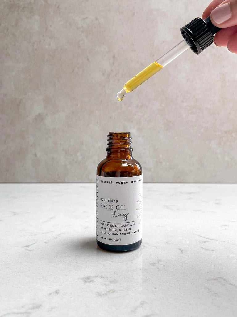 Brown glass bottle with dropper on a light marble surface