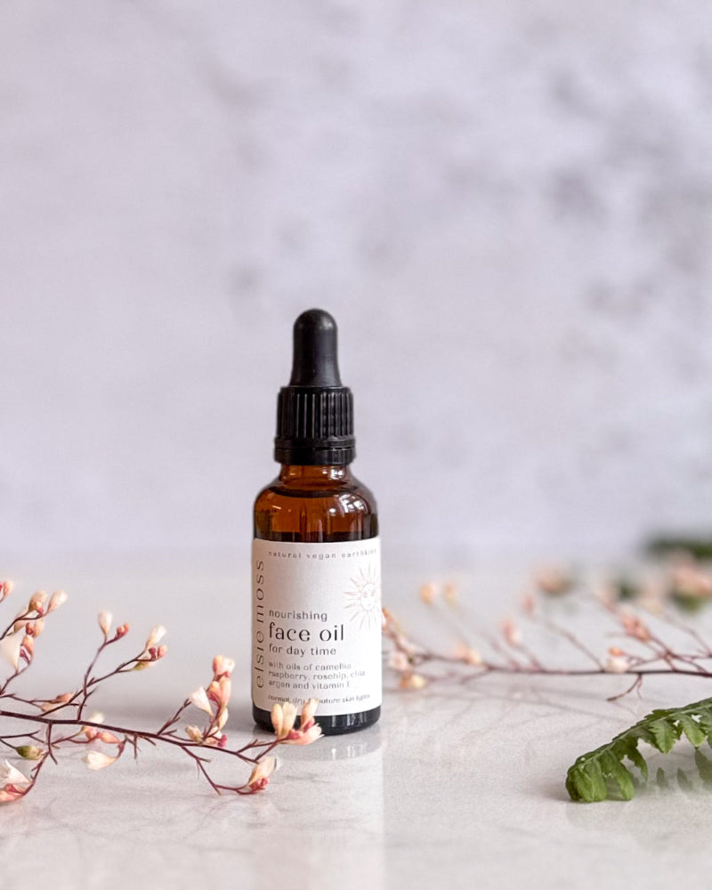 Bottle of face oil with a dropper on a light background with decorative elements