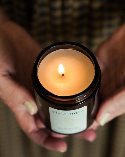 Candle in a black jar labeled &