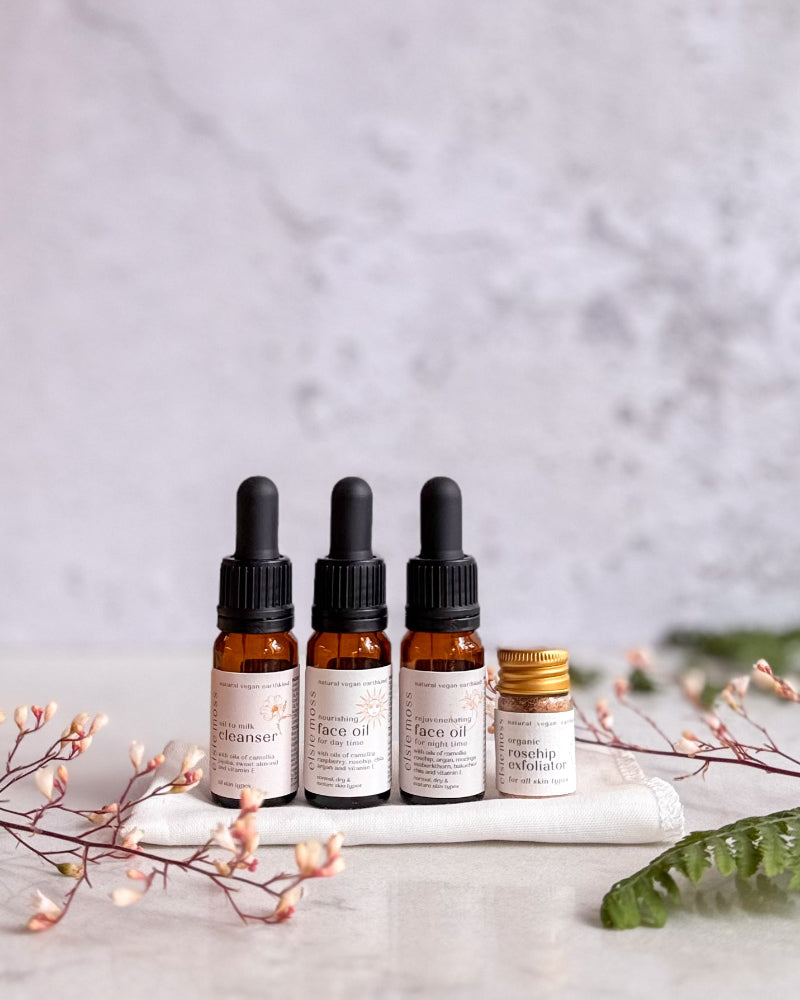 Four dropper bottles with labels on a white surface with a light gray background